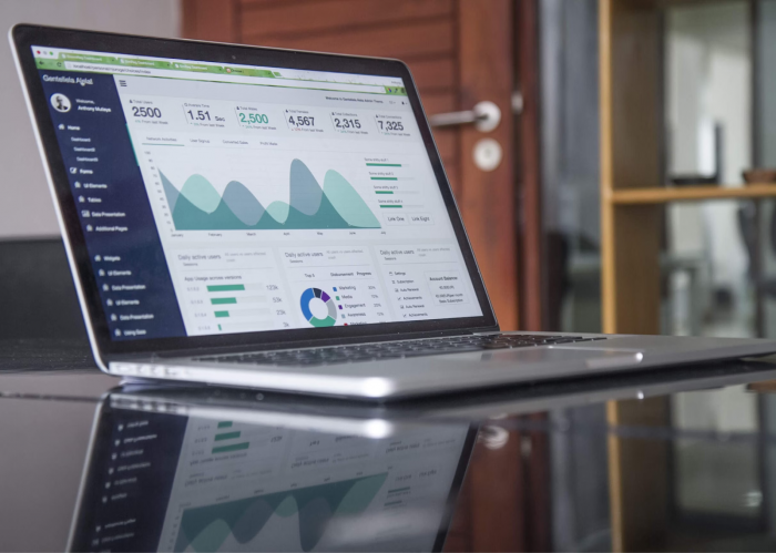 Laptop displaying analytics dashboard with charts and user data metrics on screen.
